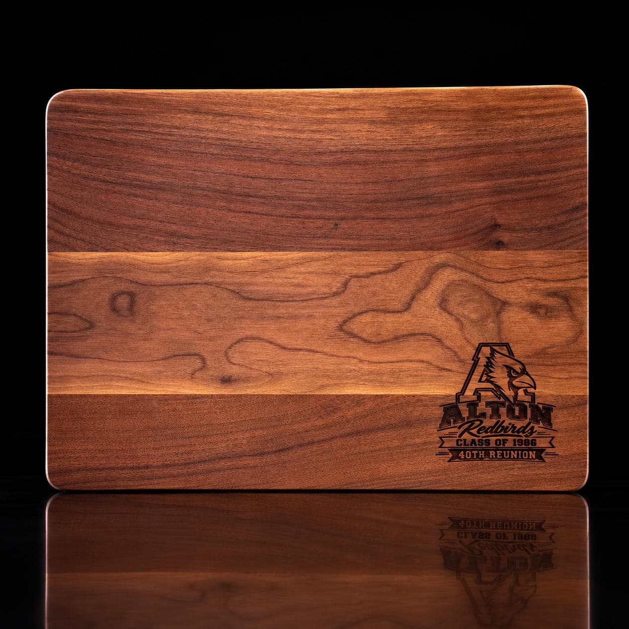 Striped hardwood board engraved with the Alton Redbirds Class of 1986 40th Reunion logo on a black reflective background.